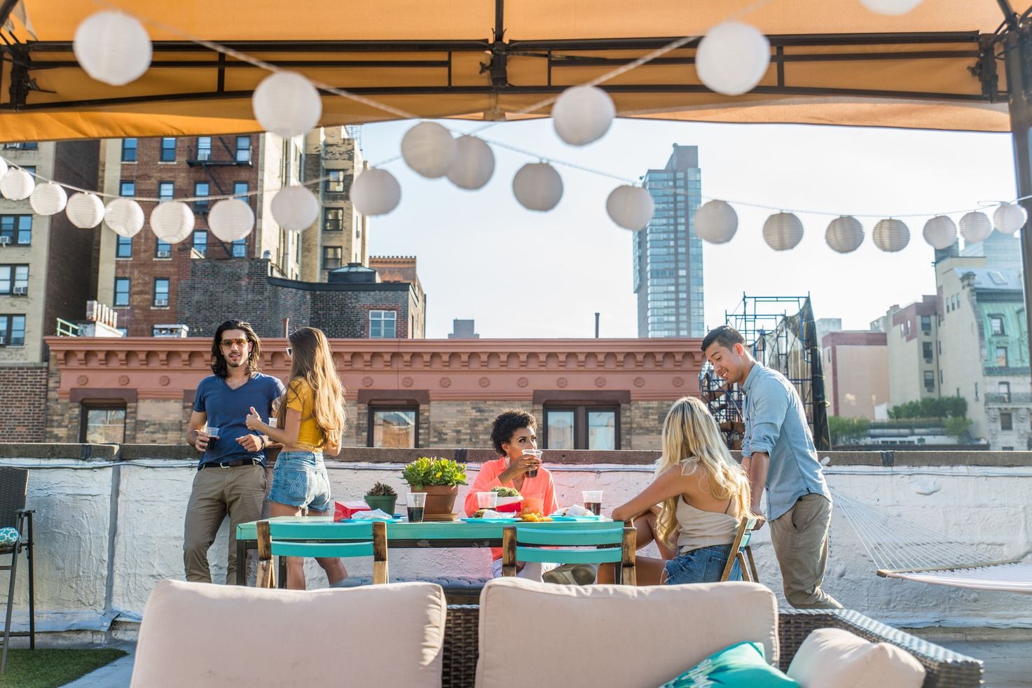 amigos protegidos bajo un techo en una terraza