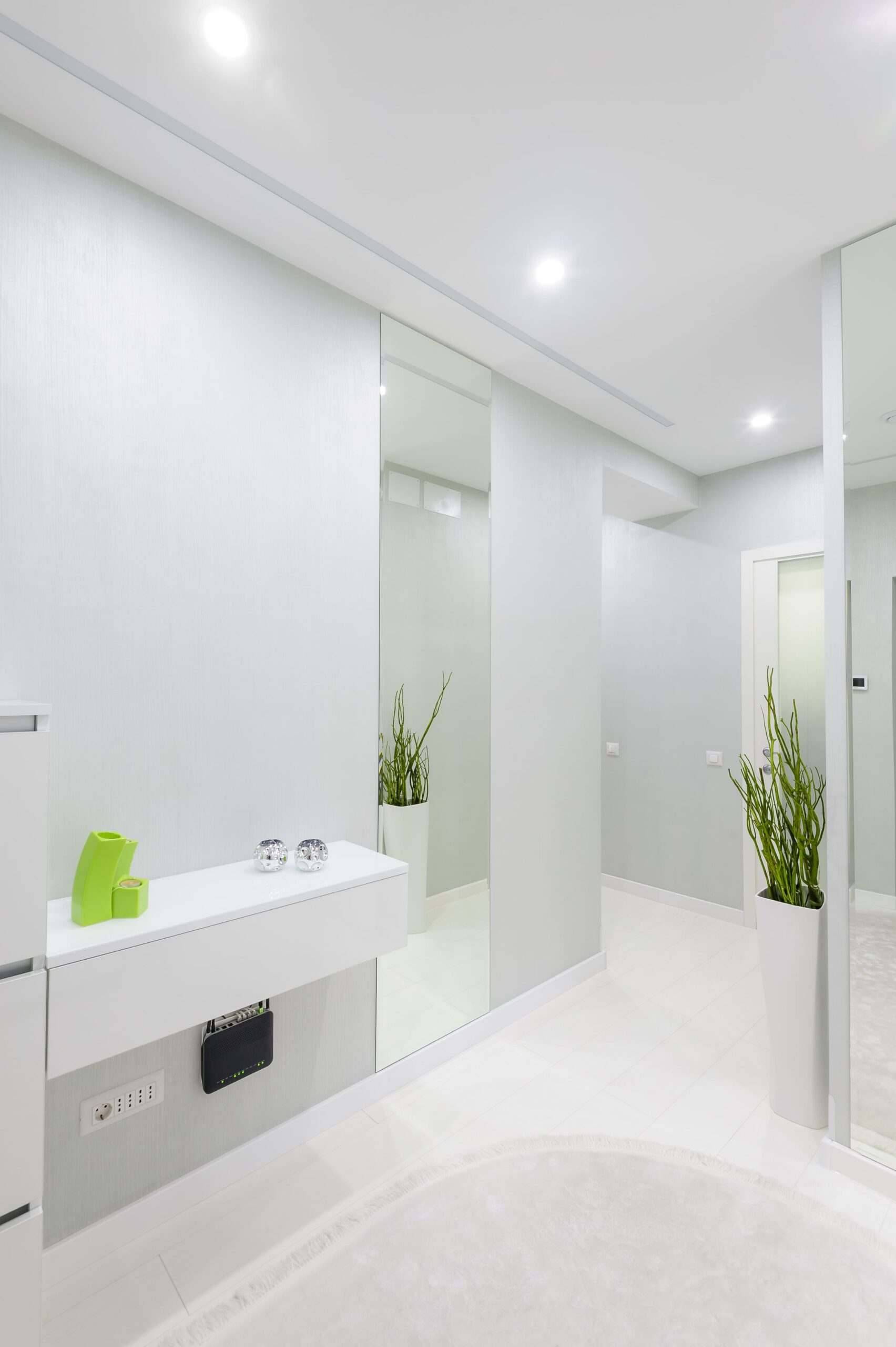 artista trabajando en un estudio de techos altos baño en tonalidades blancas, techos con iluminacion integrada y plantas