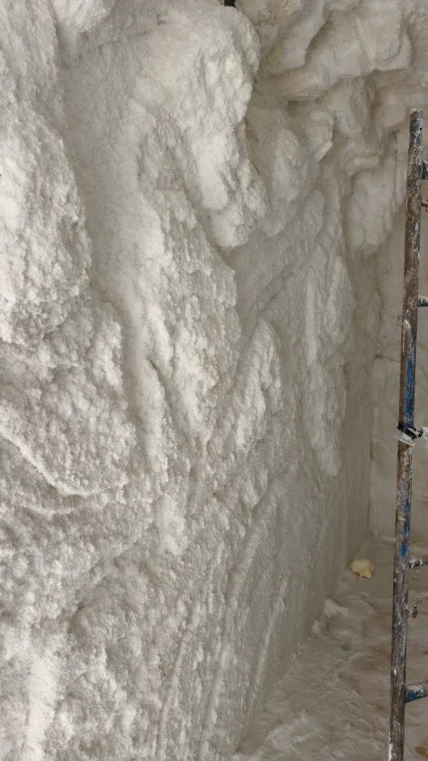 construccion-cuevas-de-sal-personalizadas Detalle del proceso de construcción artesanal de una cueva de sal personalizada con relieves tallados a mano, mostrando la textura natural del revestimiento de sal.